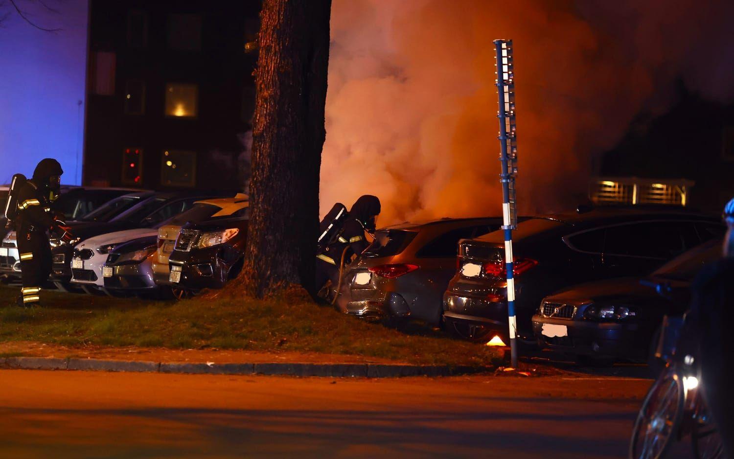 Två bilar har brunnit på en parkering i centrala Halmstad. Ytterligare en bil skadades i branden.